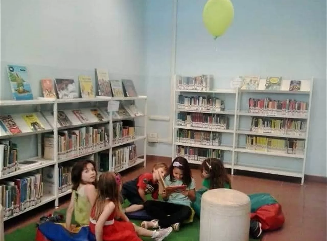 bambini seduti per terra davanti biblioteca
