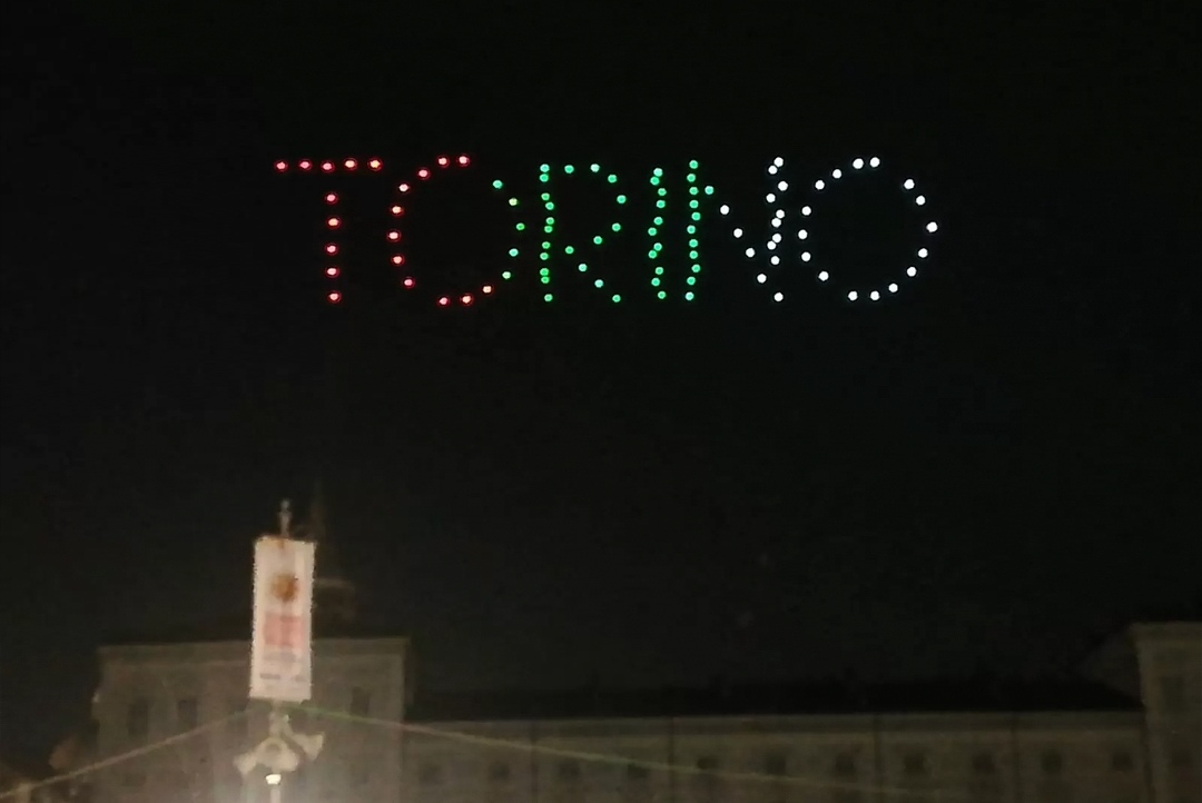 Droni in cielo di notte compongono la scritta Torino