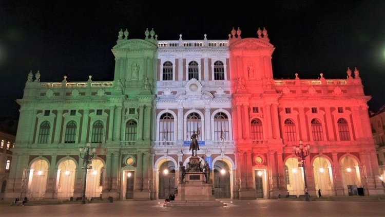 Palazzo Carignano di Torino illuminato di notte col tricolore italiano