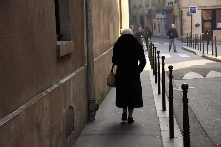 Anziana di fotografata di spalle mentre cammina