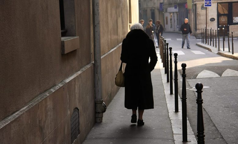 Anziana di fotografata di spalle mentre cammina