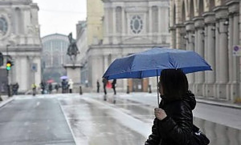 Ragazza cin ombrello sotto la pioggia in via Roma