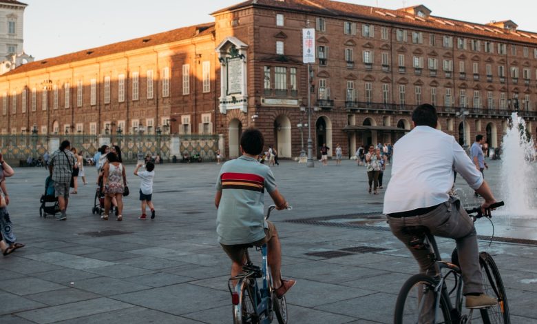 piazza castello torino, padre e figlio in bici