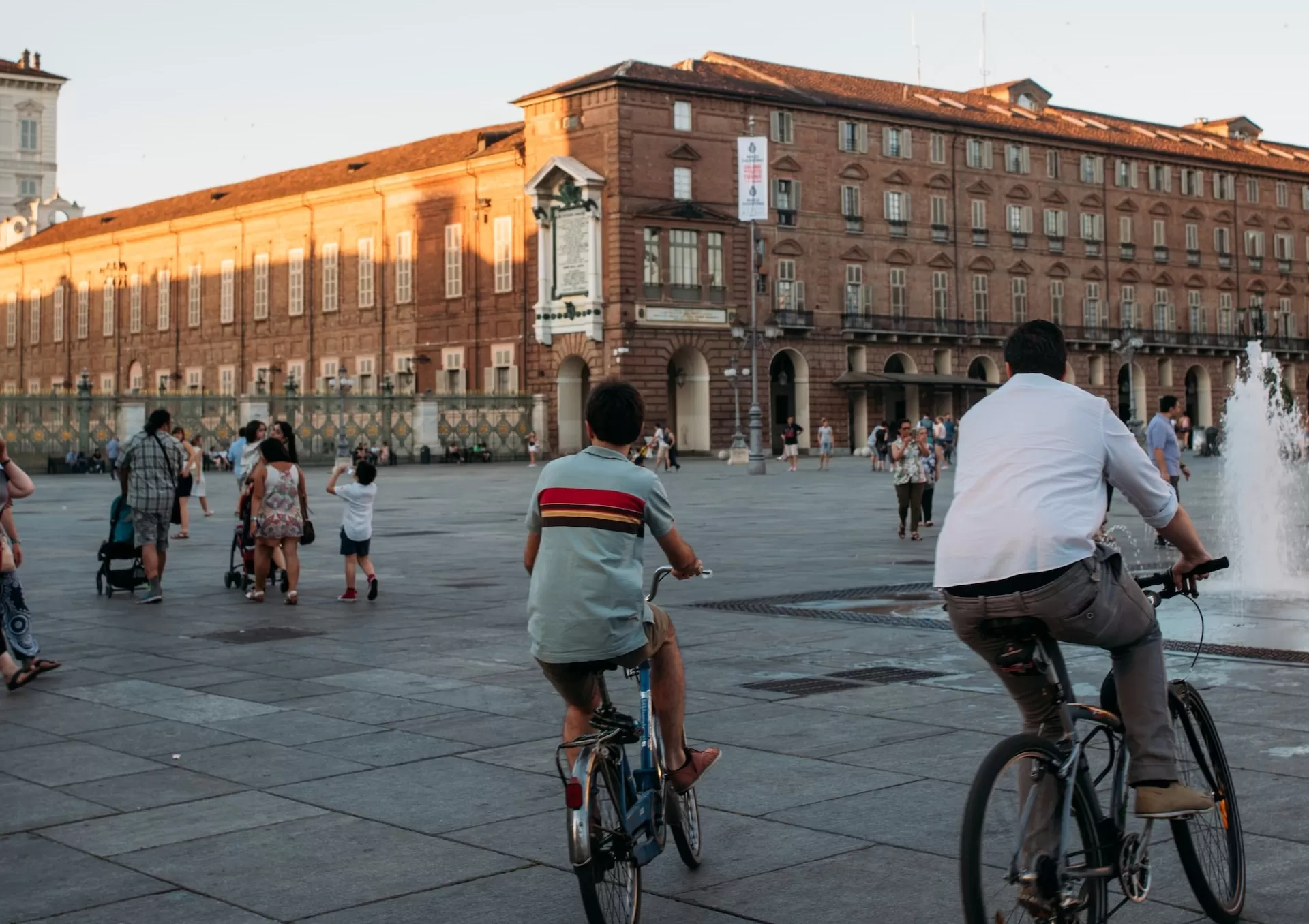 piazza castello torino, padre e figlio in bici