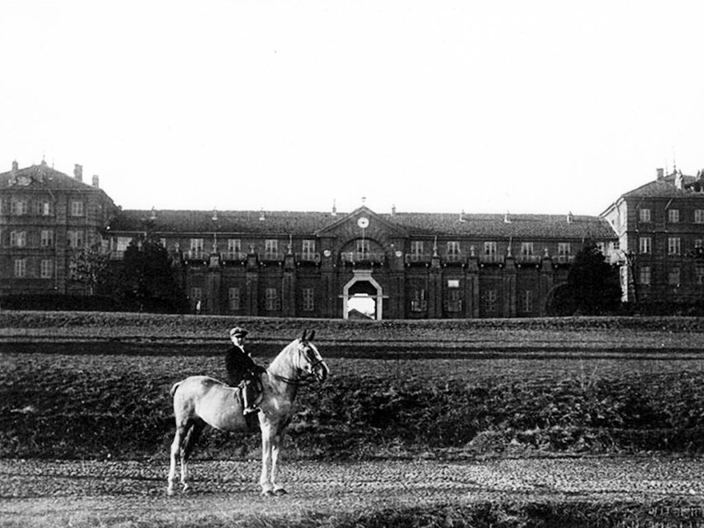 vecchia foto di ragazzo sopra cavallo bianco davanti palazzo 