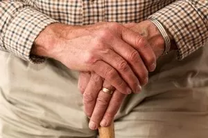 mani anziano sopra bastone