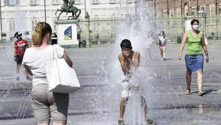 bambino si bagna nella fontana di piazza Castello di giorno