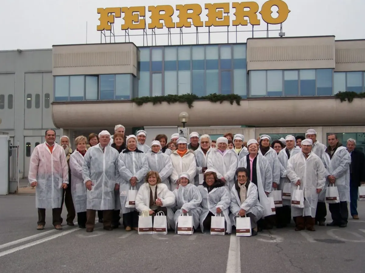 dipendenti Ferrero posano davanti alla sede di Alba di giorno