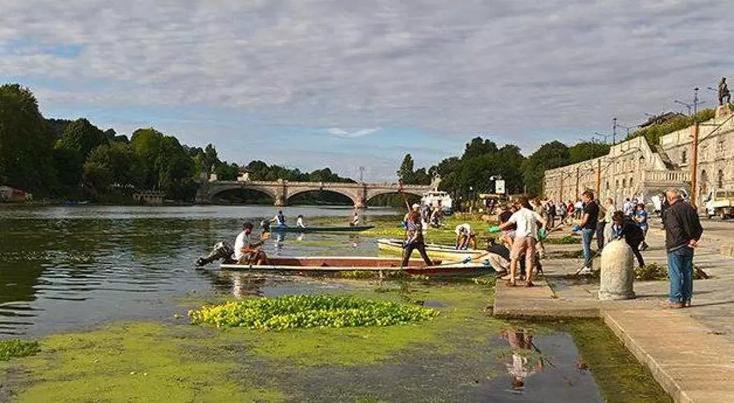 volontari in barca puliscono le sponde del fiume Po a Torino