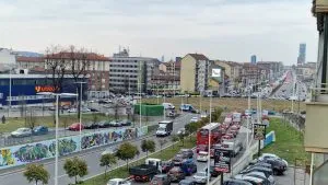 Vista di Piazza Baldissera a Torino con traffico intenso nelle ore di punta. Lunghe code di auto e autobus evidenziano i problemi di viabilità dell'area, in attesa dei lavori previsti per marzo 202