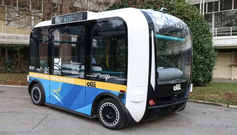 Bus a guida autonoma Torino 2025: navetta elettrica senza conducente del progetto sperimentale per il trasporto pubblico, con livrea blu e bianca, parcheggiata in un'area urbana