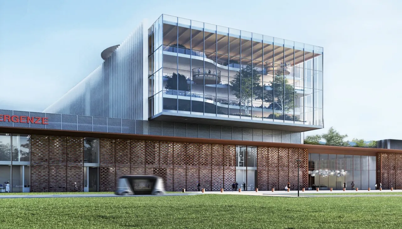 Rendering del futuro Ospedale di Cambiano, una struttura moderna con ampie vetrate e spazi verdi interni. In primo piano, l'ingresso dell'area emergenze, con design innovativo e sostenibile