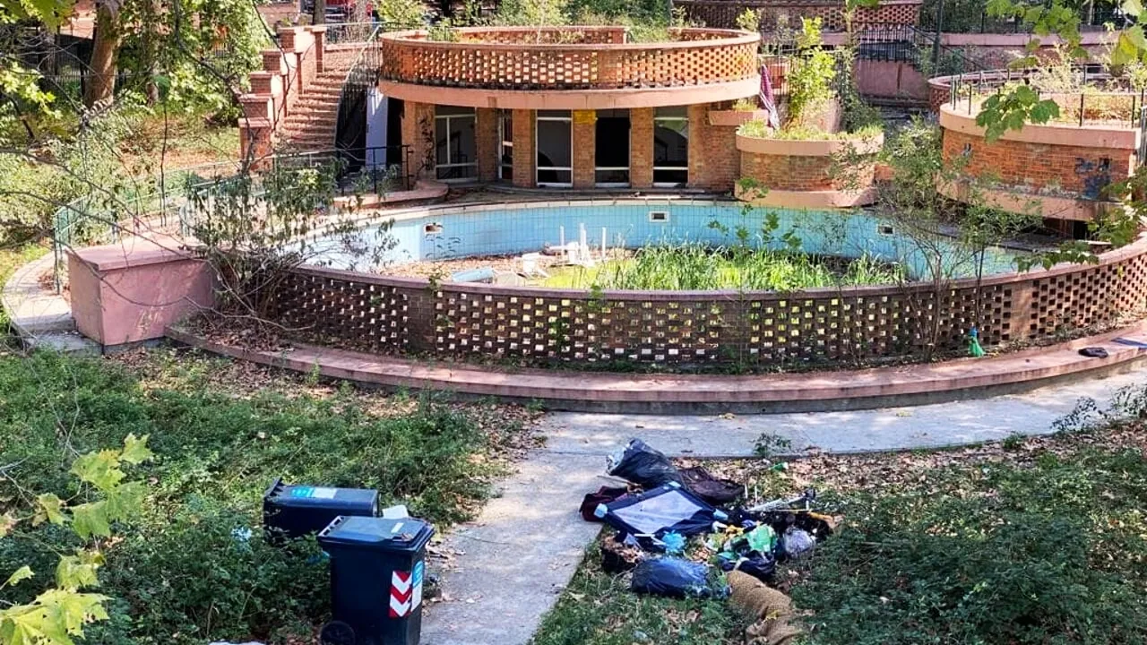 Stato di degrado delle Piscine Sempione a Torino, con vasca abbandonata, erba alta e rifiuti, in attesa del progetto di riqualificazione