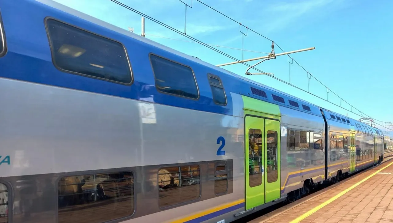 Treno TAF a due piani in servizio sulla ferrovia Torino-Ceres, fermo in stazione sotto linea elettrica aerea