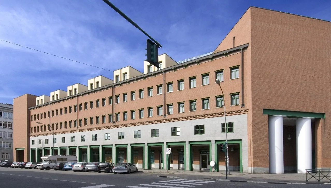 Vista esterna dell’edificio storico che ospitava la sede principale del Gruppo Finanziario Tessile (GFT) nel quartiere Barriera di Milano Torino, simbolo dell’industria tessile italiana del XX secolo.