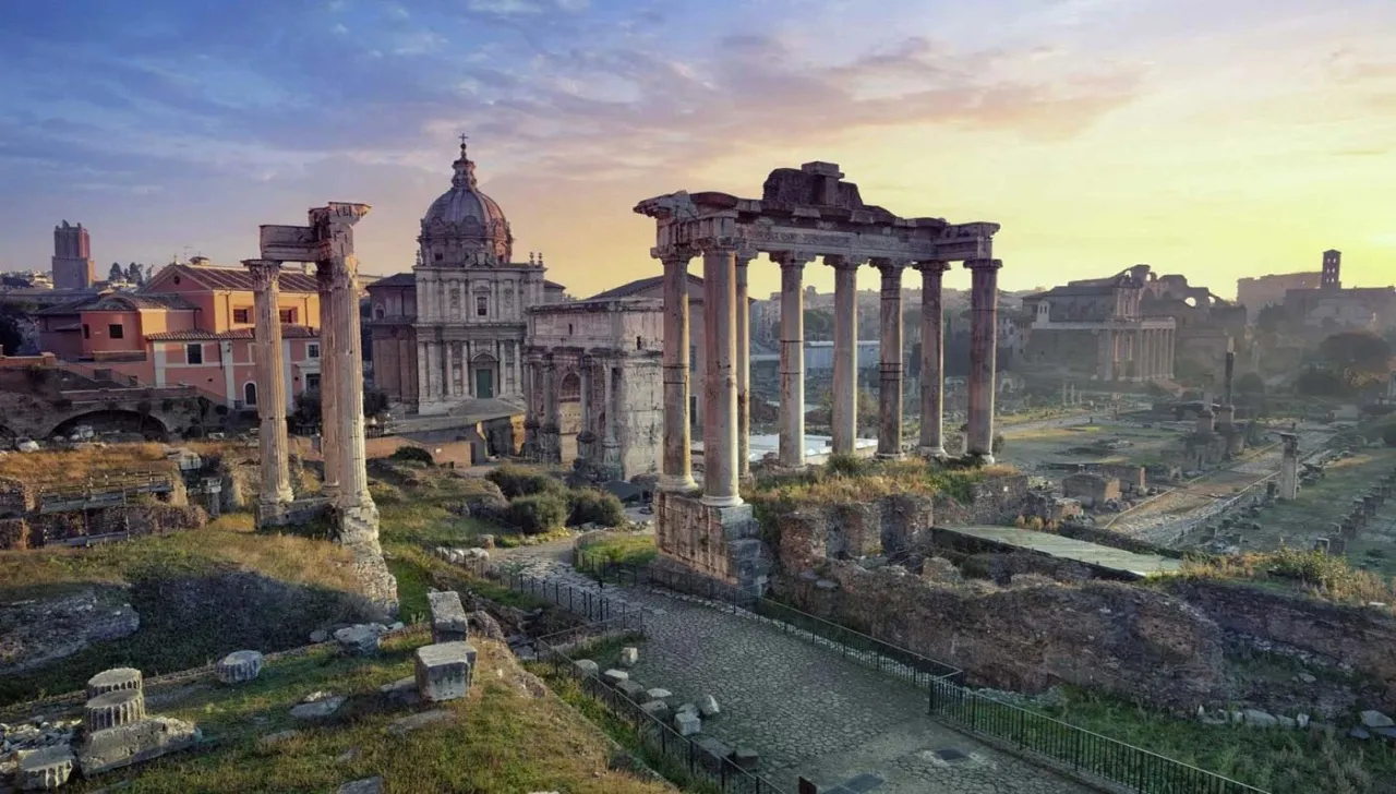 Veduta al tramonto del Foro Romano a Roma, con le colonne del Tempio di Saturno e la cupola di Santi Luca e Martina sullo sfondo, meta perfetta da esplorare grazie al volo Torino Roma 2025