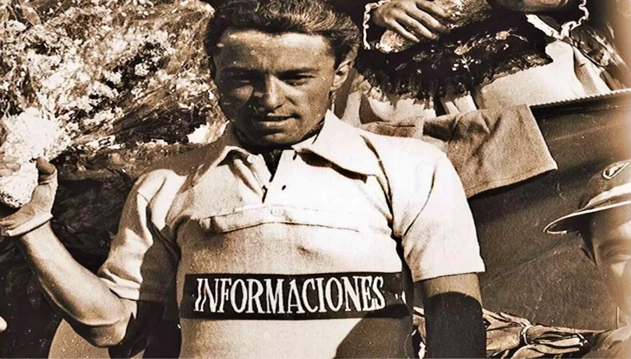 Angelo Conterno , in una foto in bianco e nero, con la maglia di leader alla Vuelta di Spagna 1956 e un mazzo di fiori nella mano destra