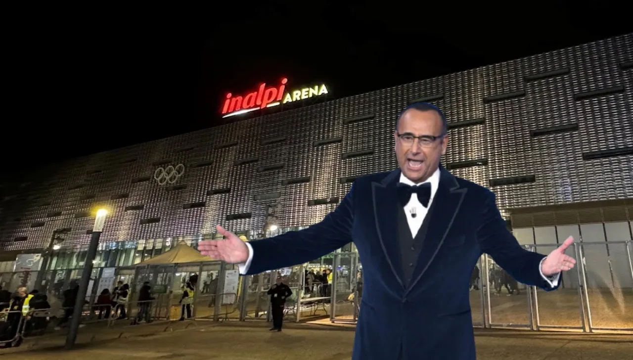 Carlo Conti in smoking con le braccia allargate davanti all'entrata dell'Inalpi Arena la sera