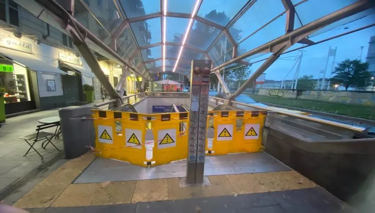 Ingresso della metropolitana di Torino con scala mobile fuori servizio e transennata da barriere gialle di sicurezza in corso Inghilterra