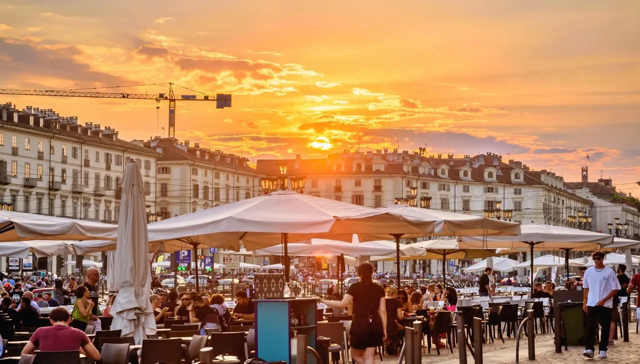 Torinesi nei dehors di piazza Vittorio Veneto durante un tramonto d’agosto 2025: la città rimane viva nonostante le partenze estive