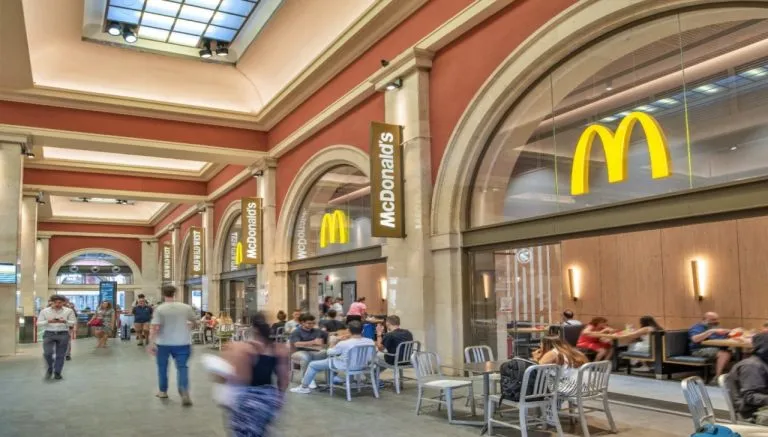 McDonald’s all’interno della stazione di Porta Nuova a Torino, con area ristoro e tavoli sotto i portici interni
