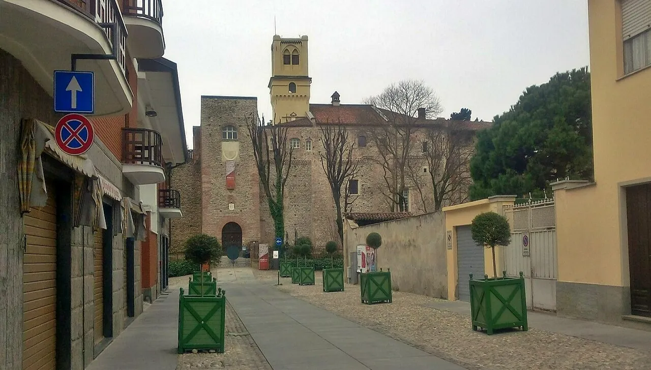 Il Castello Orsini di Rivalta di Torino visto dal centro storico, con mura medievali e torre campanaria sullo sfondo