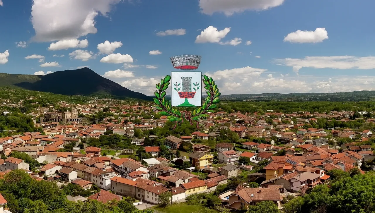 Veduta panoramica di Villar Dora con lo stemma comunale in sovrimpressione, sullo sfondo il Monte Musinè e la Valle di Susa
