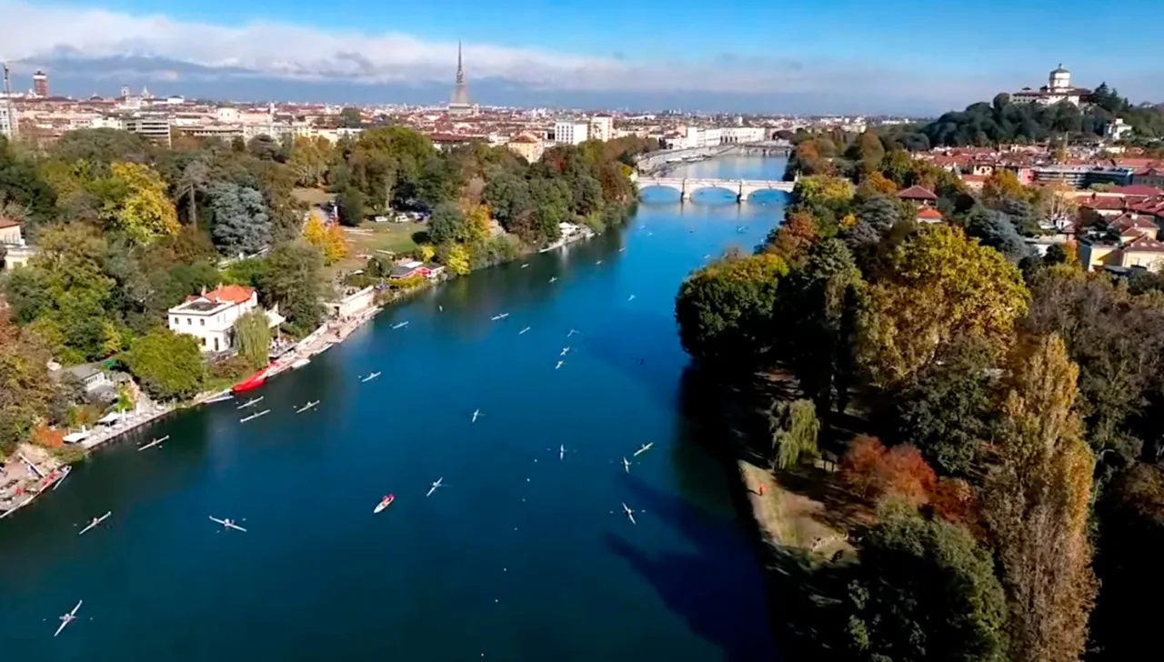 Veduta aerea del fiume Po a Torino durante la regata SilverSkiff, con numerose imbarcazioni in gara e i monumenti storici della città sullo sfondo, tra cui la Mole Antonelliana e il Monte dei Cappuccini
