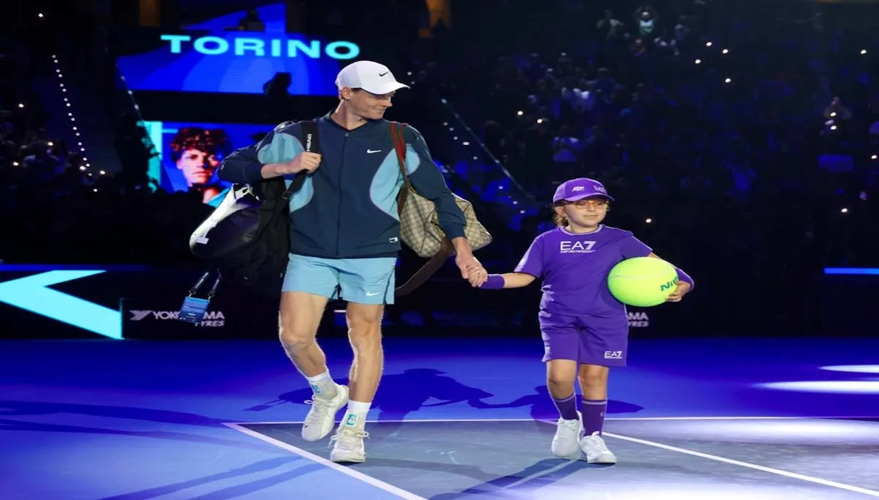 Ingresso in campo a Torino: Jannik Sinner con cappellino e borsoni accompagna una bambina dell'ospedale Regina Margherita, mascotte con maxi pallina da tennis